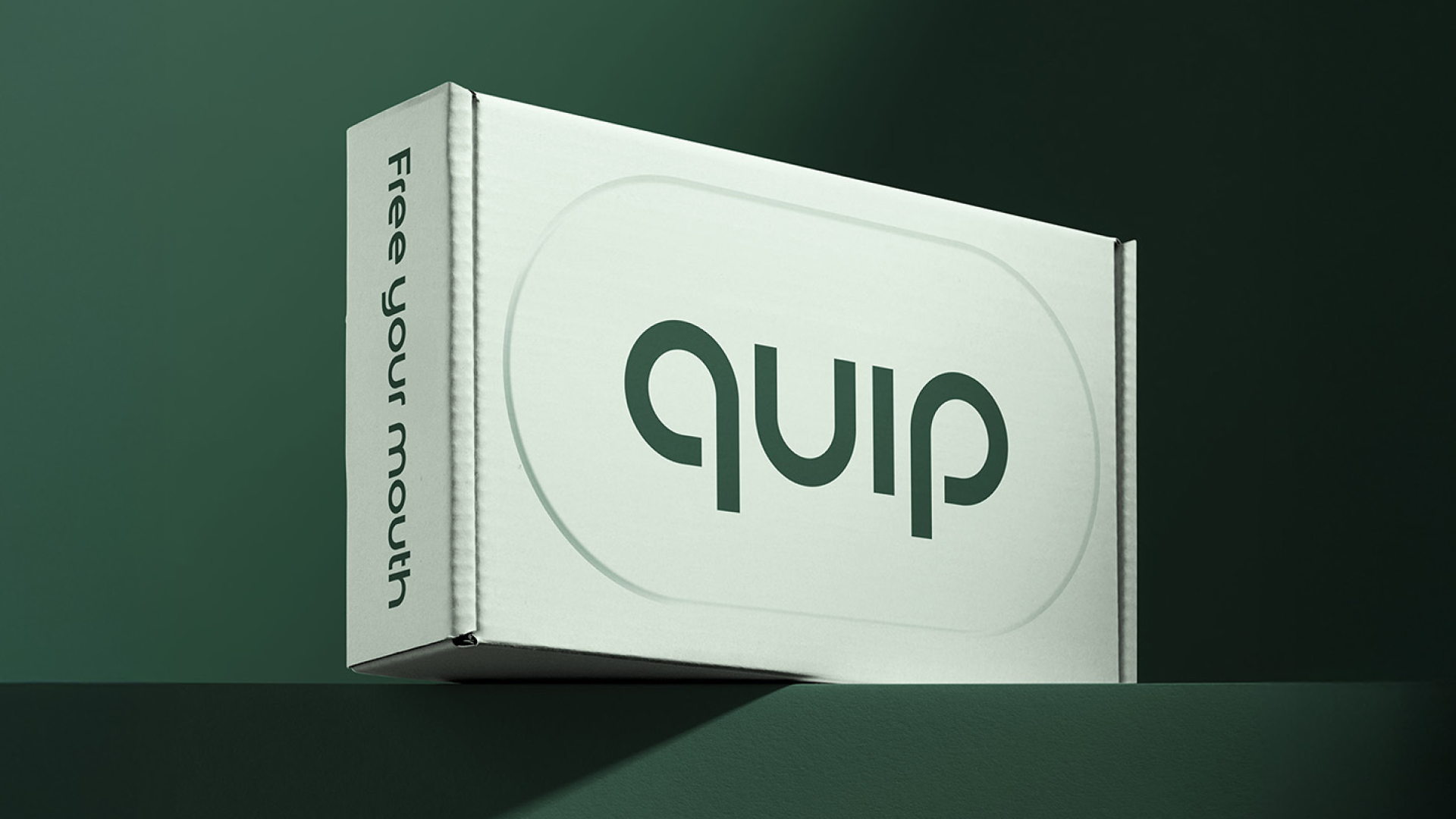 quip product carton with a rounded geometric wordmark on a muted green background.
